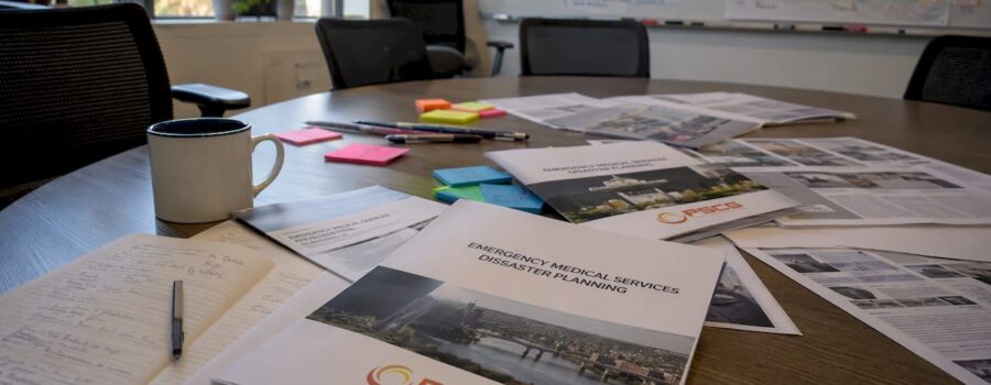 EMS disaster plan documents with PSCG Logo on conference table