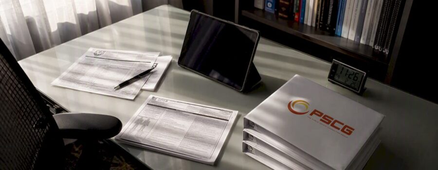 Desk with EMS reports and PSCG logo manuals